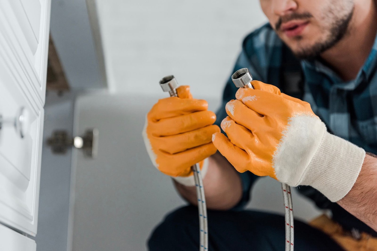 Handyman repairing a metal hose